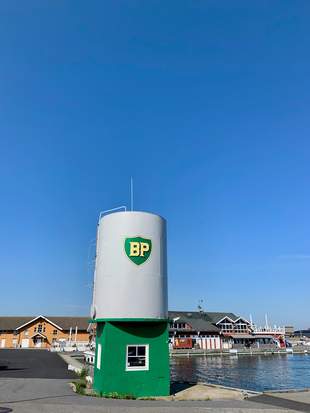 Torre gris y verde cerca del cuerpo de agua