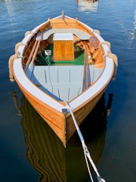 empty gray and brown boat on calm body of water