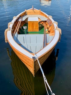empty gray and brown boat on calm body of water