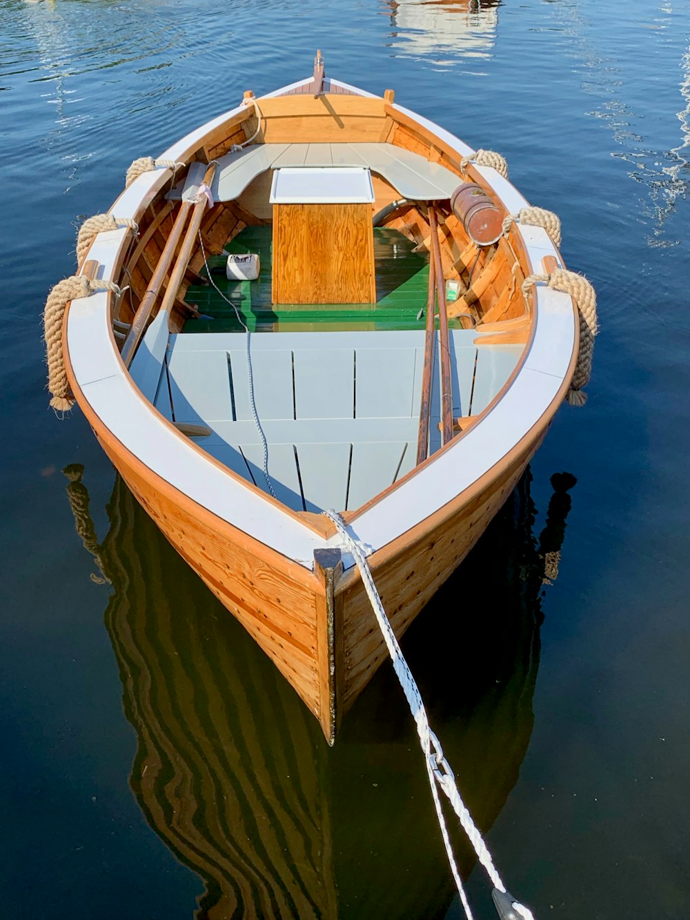 empty gray and brown boat on calm body of water