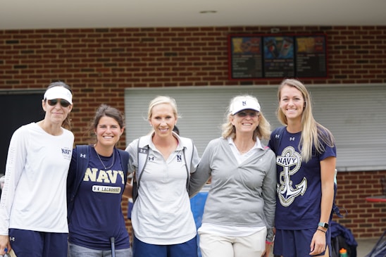 A group of diverse women in maritime gear smiling on a dock with Chicago’s skyline behind them.