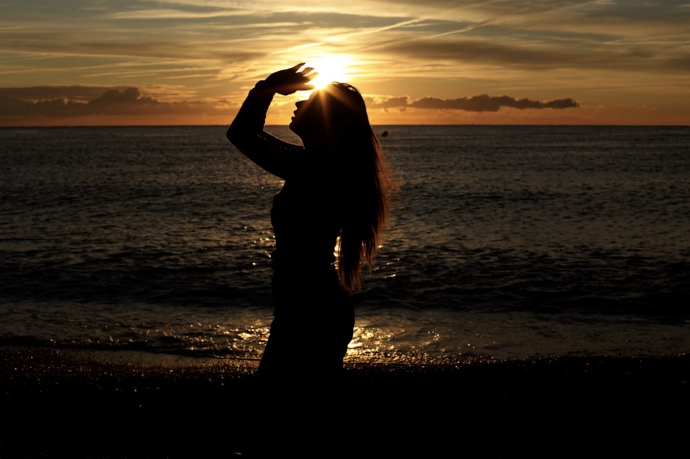 silhouette of woman near ocean