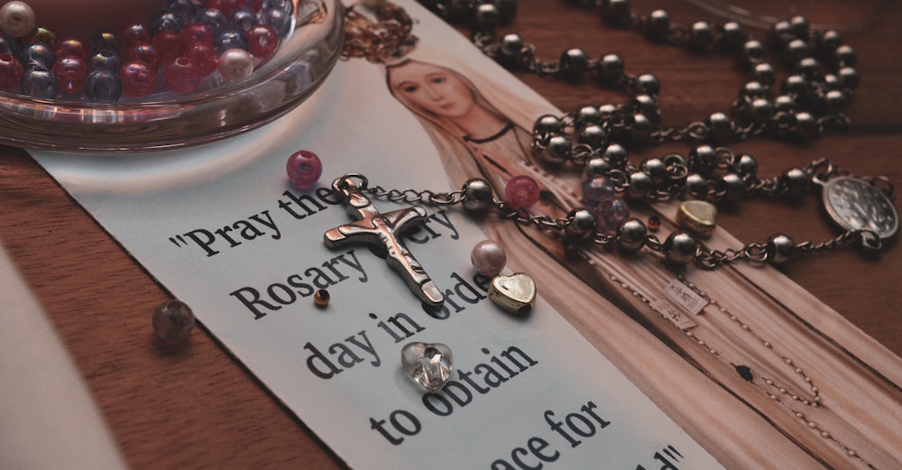 silver and black rosary on nun graphic paper
