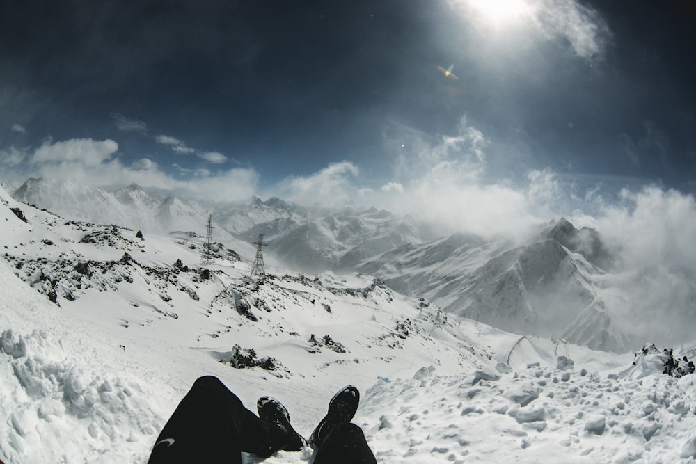 a person sitting on top of a snow covered slope