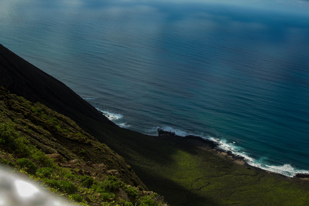 aerial photography of green mountain cliff and blue sea