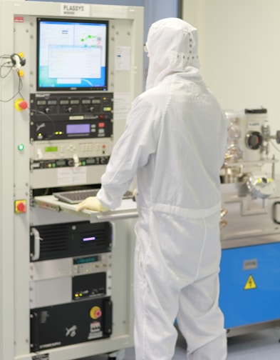 man using computer in cleanroom suit