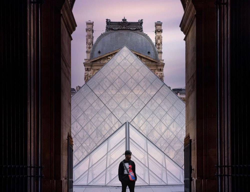 man standing outside The Louvre Museum