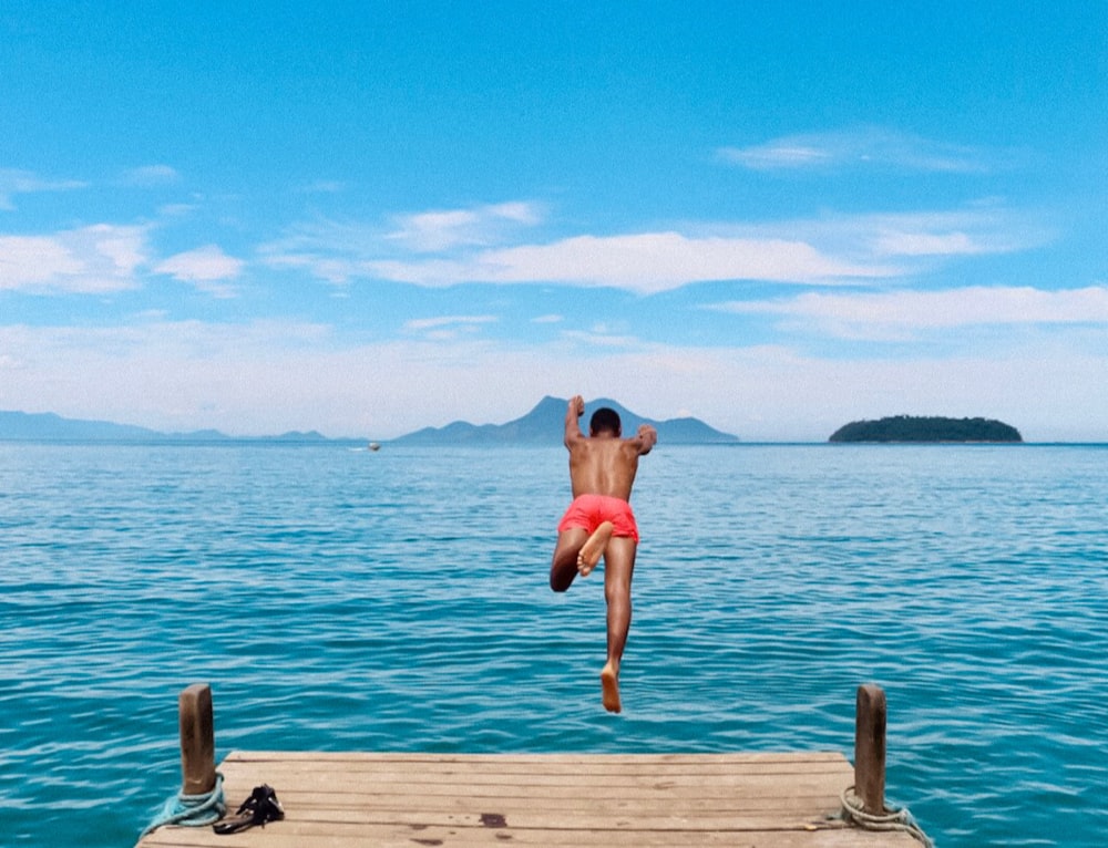 time-lapse photography of man diving into the blue sea