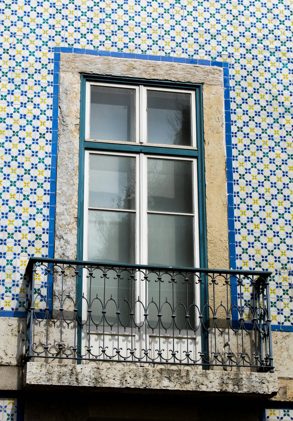 a balcony with a window and a wrought iron railing