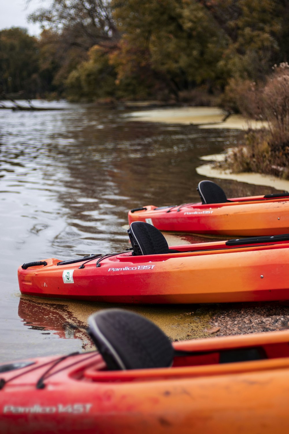 three red boats on body of water