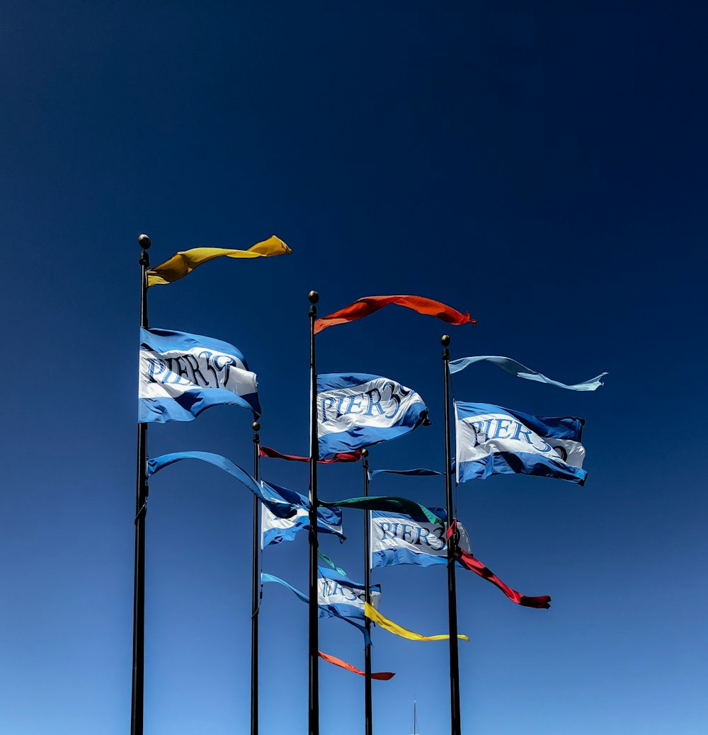 assorted flags on poles during day