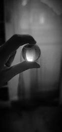 A close-up of hands holding a clear glass globe symbolizing transparency and trust.