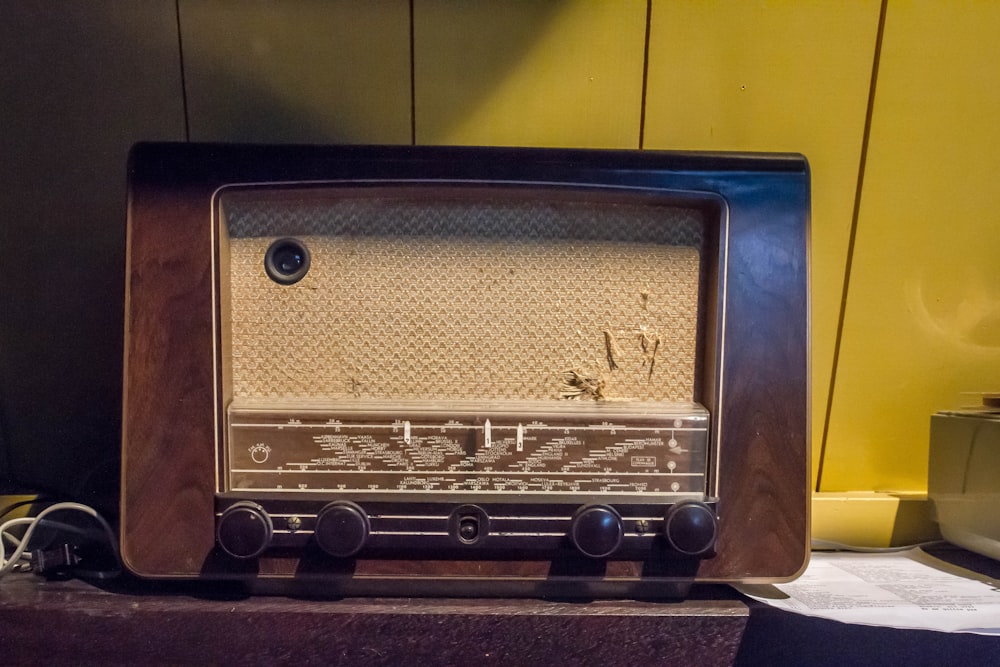 brown and gray transistor radio beside wall