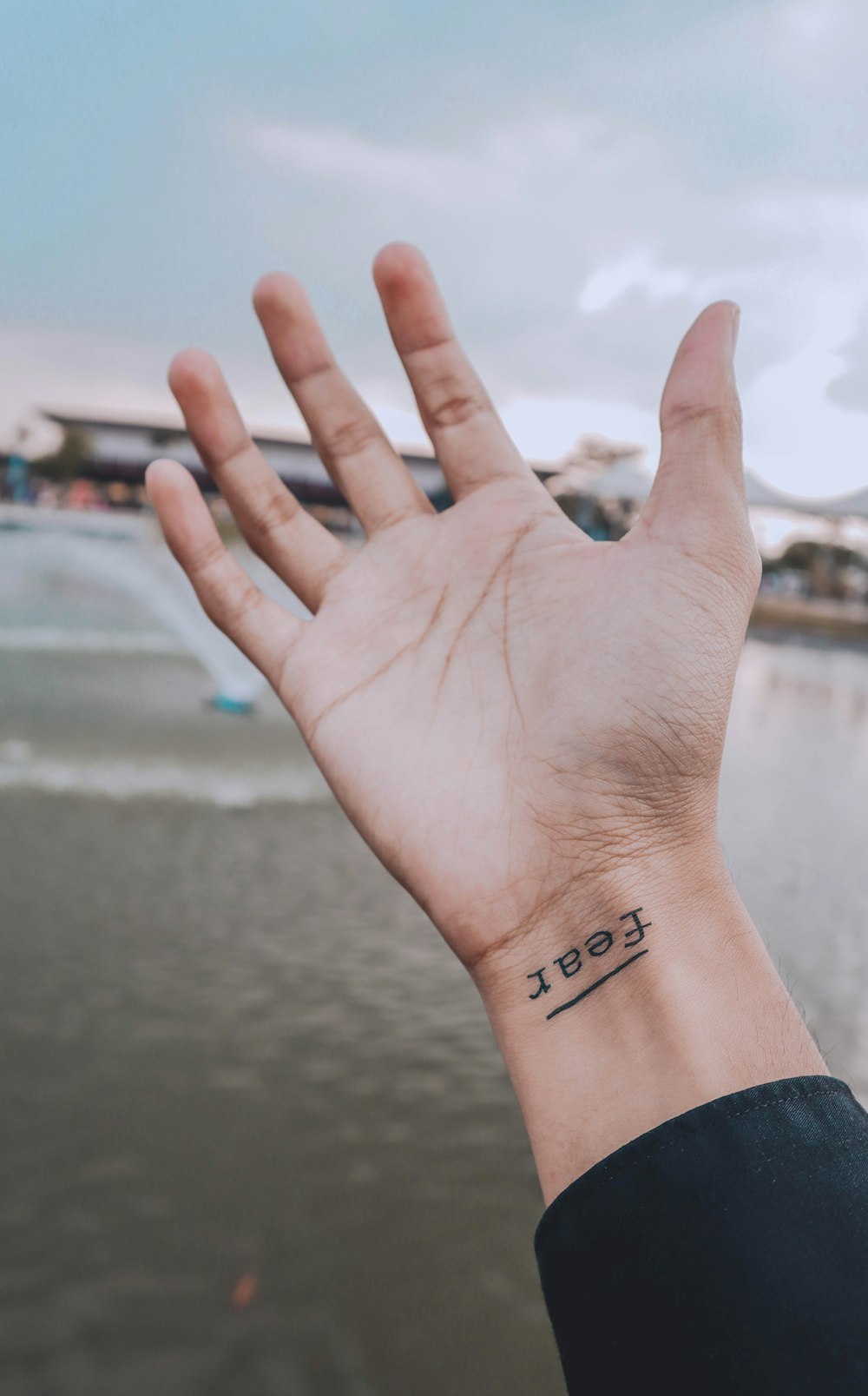 Person zeigt rechtes Handgelenk mit Angst-Tattoo