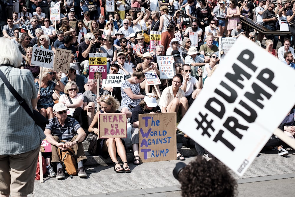 people with banners sitting beside road