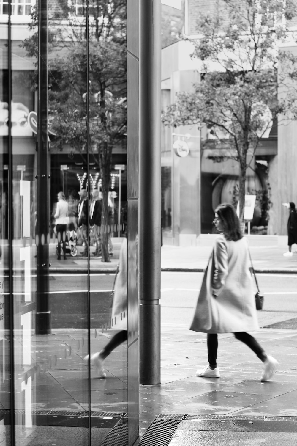 grayscale photo of woman in overcoat