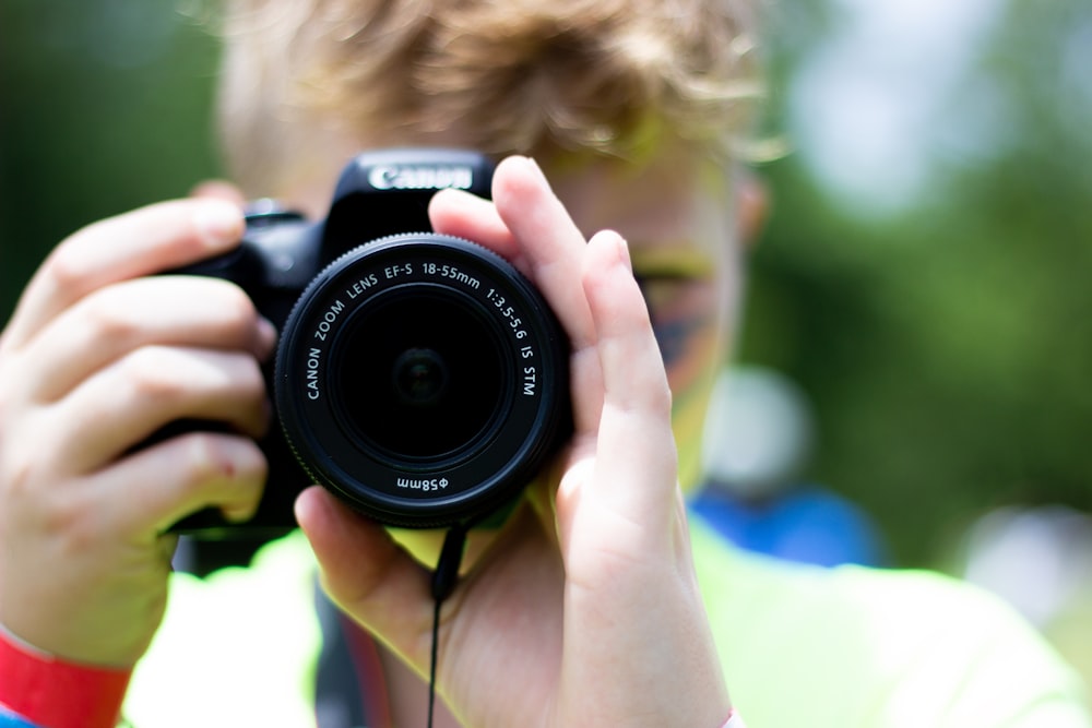 person using black Canon DSLR camera