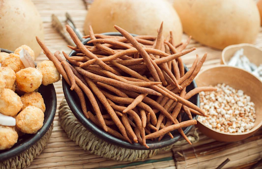 Close-up of crunchy makhana snacks spilling from a rustic bowl on a wooden table.