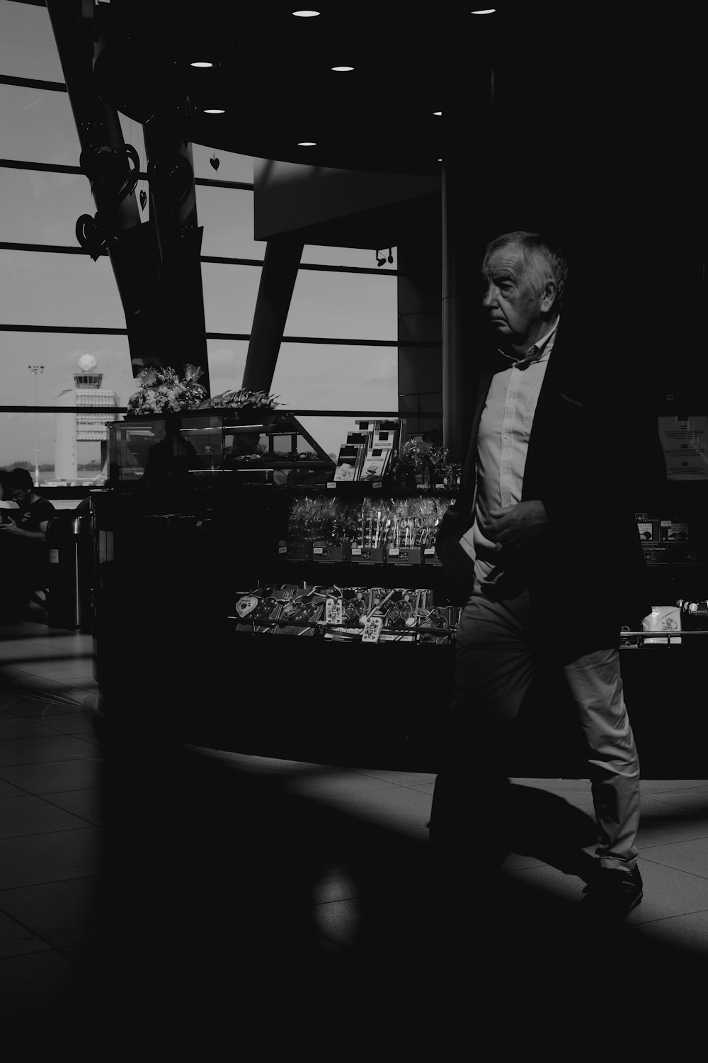 a man in a tuxedo walking past a fruit stand