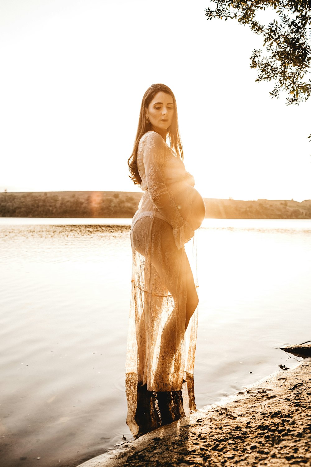 pregnant woman standing on body of water