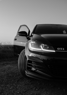 Side angle of a sleek black SUV on a gravel road