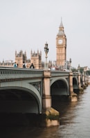 people on bridge near Queen Elizabeth tower under gray skies