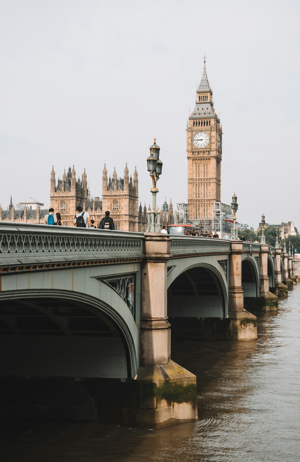 Menschen auf Brücke in der Nähe des Queen Elizabeth Towers unter grauem Himmel