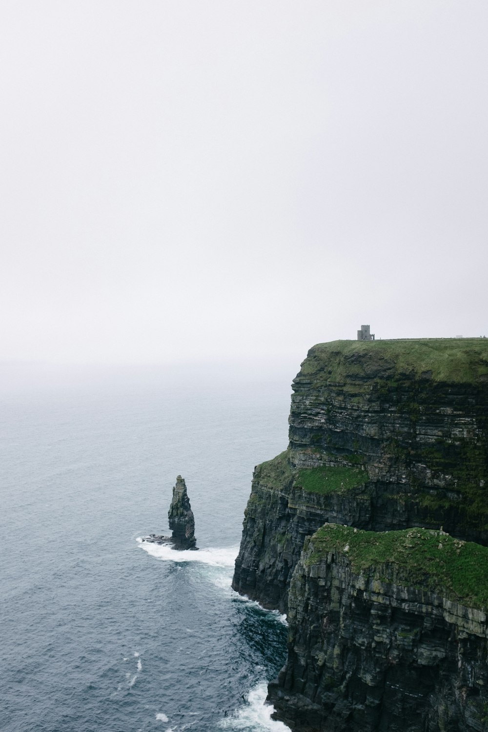 green and gray rock formation beside sea