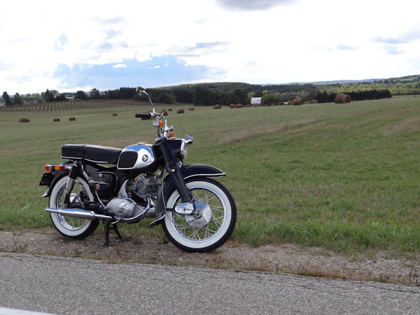 A classic motorcycle parked beside a rustic countryside road