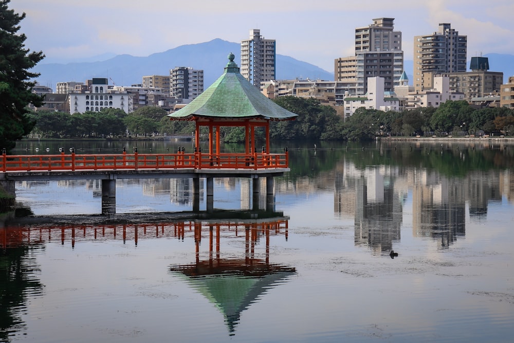 昼間の建物や木の近くの赤いガゼボ