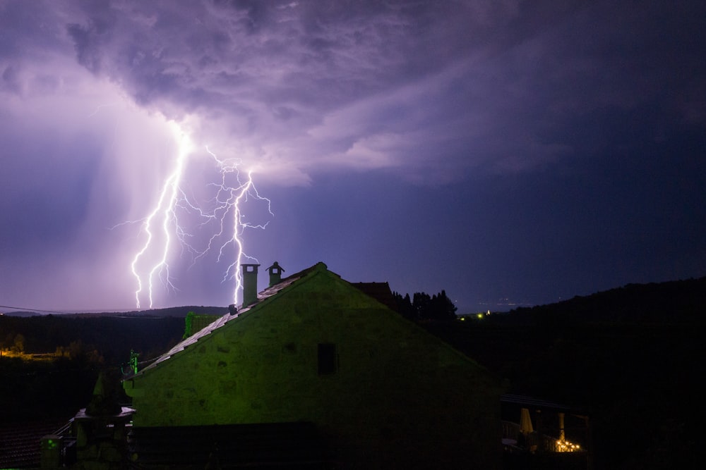 Ein Blitz schlägt nachts über einem Haus ein