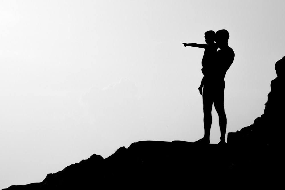 silhouette of man carrying child