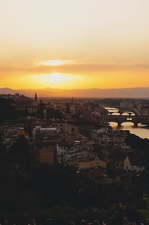 A picturesque European cityscape with historic buildings and a sunset.