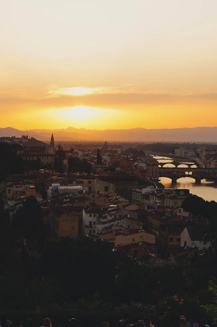 A serene sunset over a historic European cityscape with warm golden light.