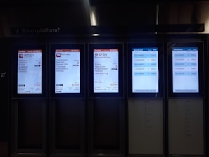 Dispatcher speaking on headset with multiple screens showing routes and schedules.