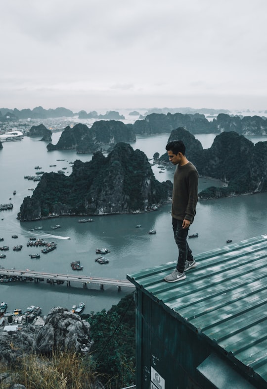 man wearing gray sweater standing on rooftop in Poem Mountain Vietnam