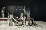 Close-up of a sleek stainless steel bar tool set resting on a crisp white surface.
