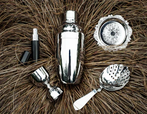 Close-up of sleek stainless steel bar tools arranged neatly on a crisp white surface.