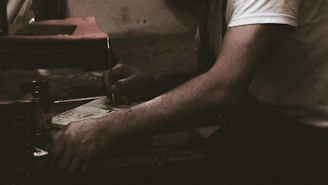An editorial-style photo of a thoughtful person writing, surrounded by white space and gentle shadows.