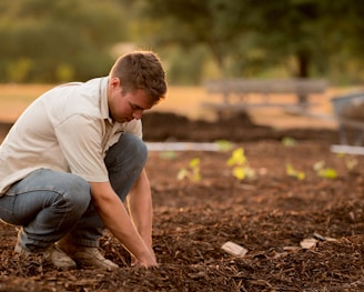 man in white shirt planting at daytime