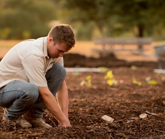 man in white shirt planting at daytime