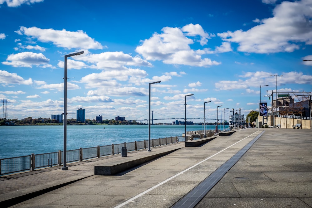 grey light posts beside body of water