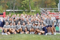 Group shot of a high school girls' softball team proudly lined up in matching apace athletics gear.