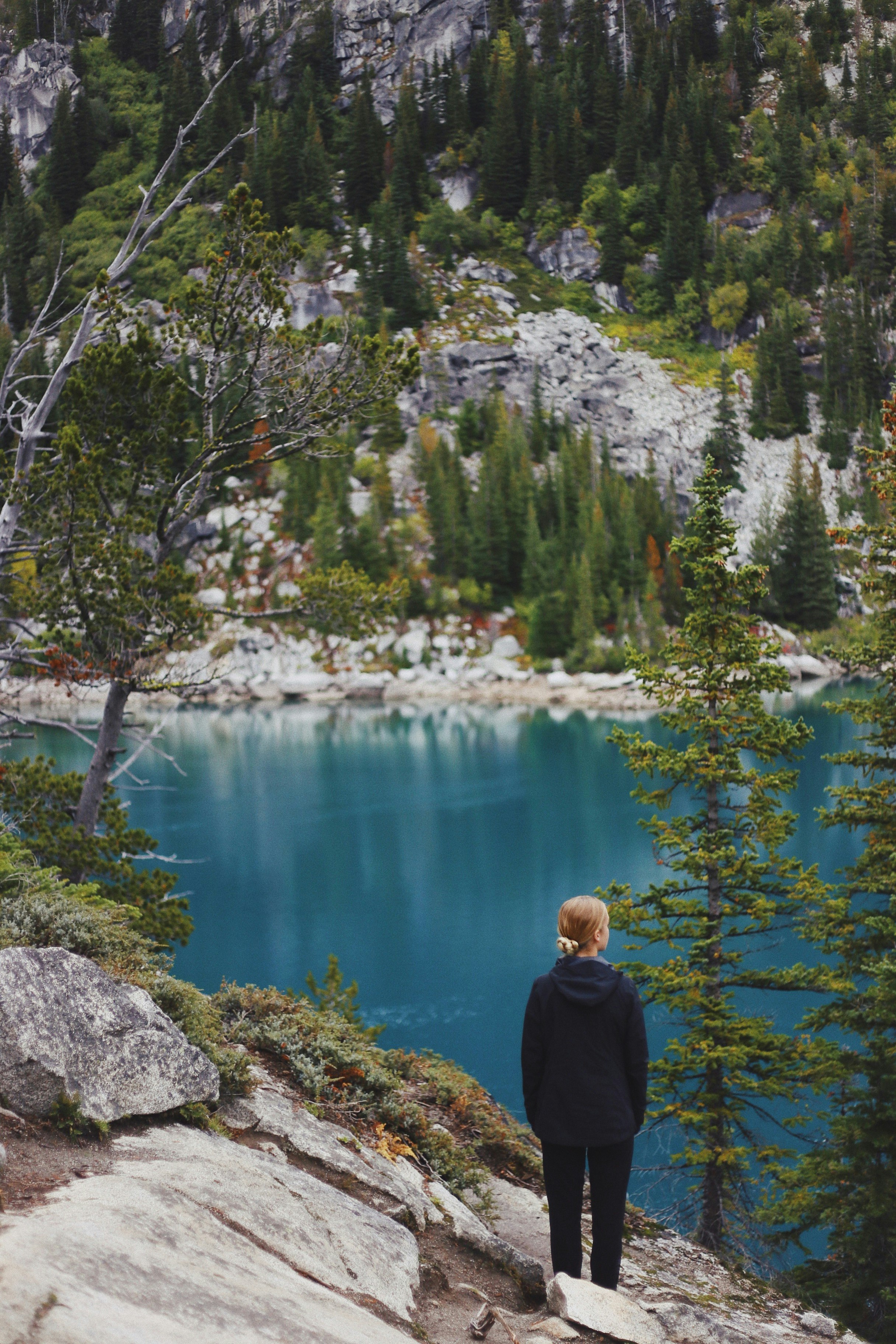 woman standing near trees and body of water