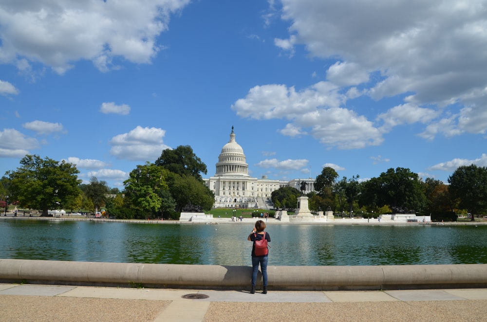 woman standing and taking photo of dome building