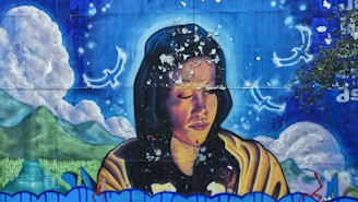 A mural depicting a person with closed eyes, surrounded by celestial imagery including glowing birds and a serene landscape with mountains and clouds. The mural has a weathered texture with visible peeling paint.