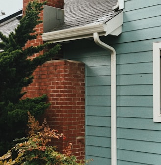 a blue house with a red brick chimney