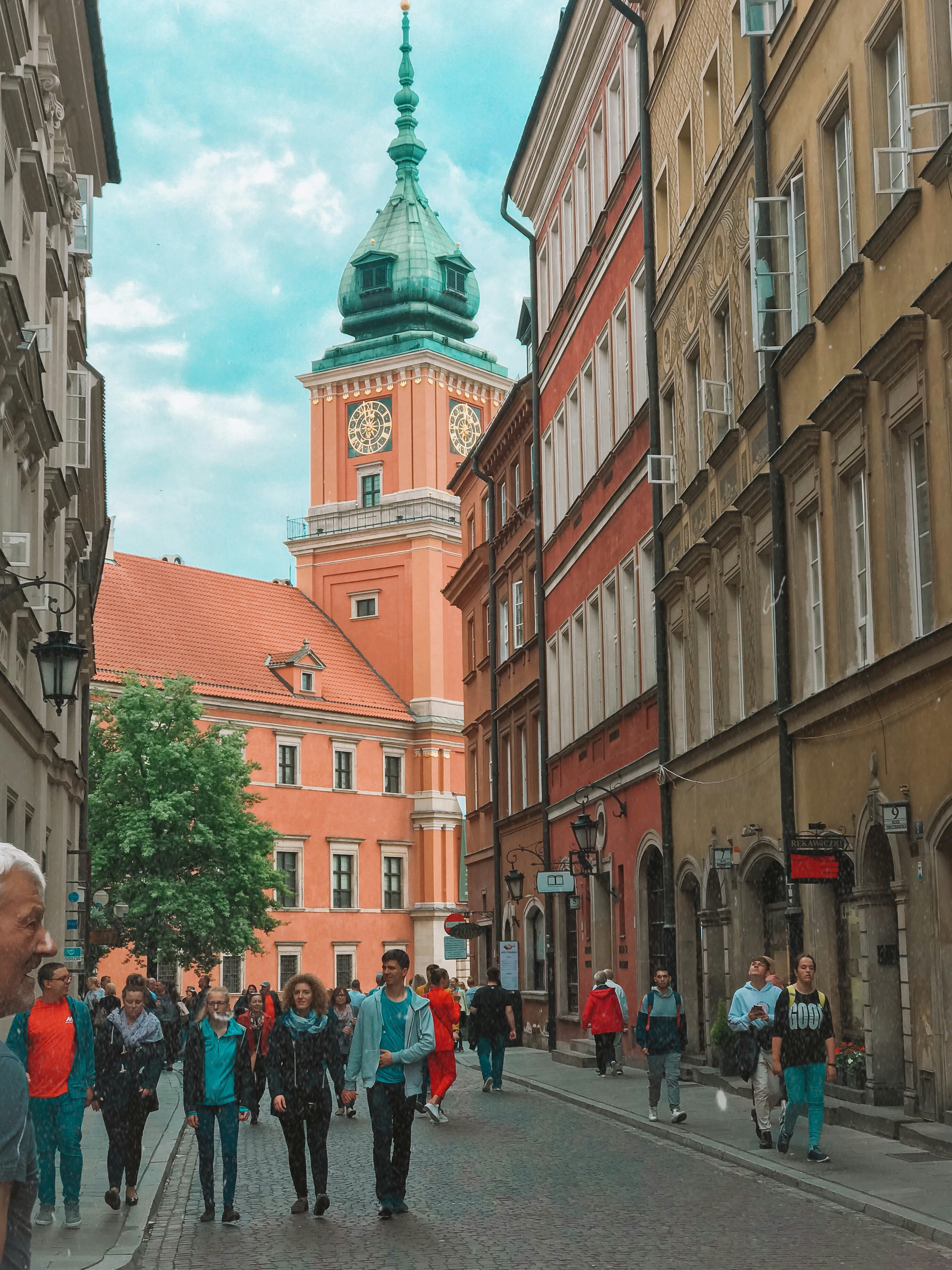 people walking by peach-colored building at daytime