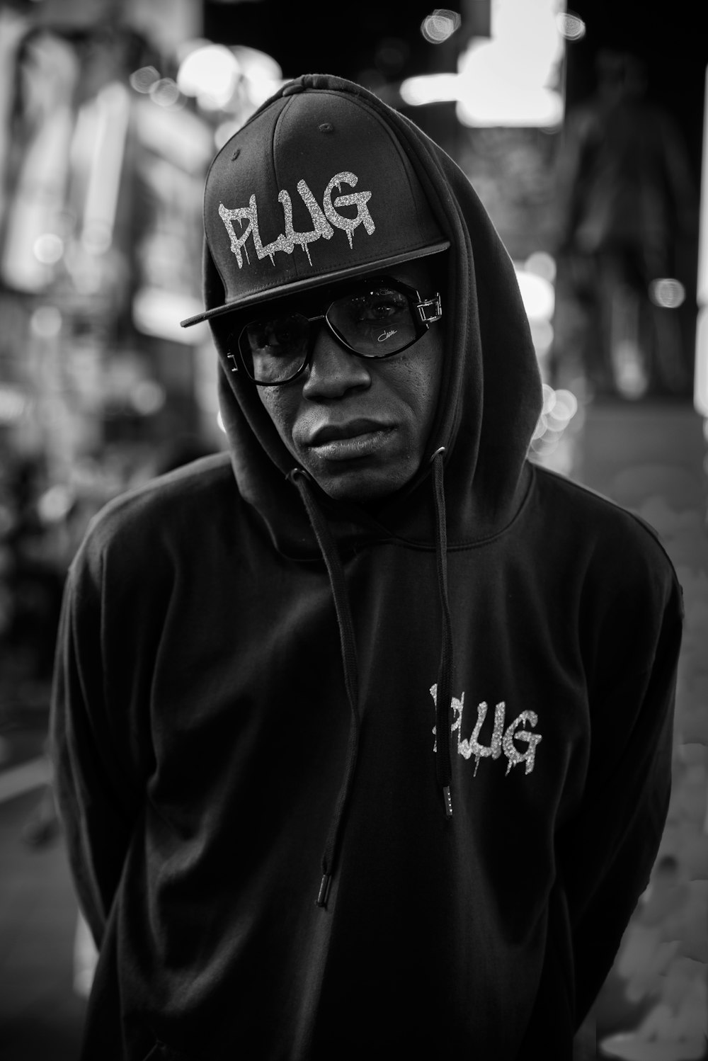 grayscale photography of man in hoodie with fitted cap