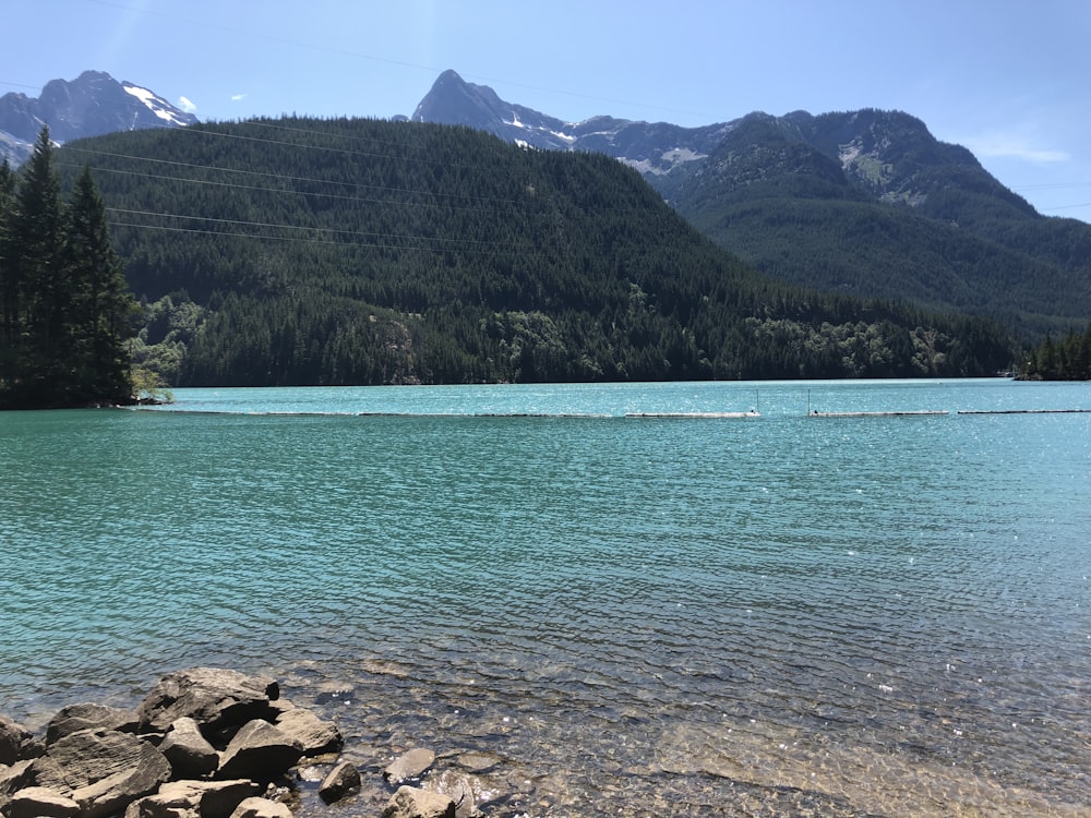 calm body of water near mountain during daytime